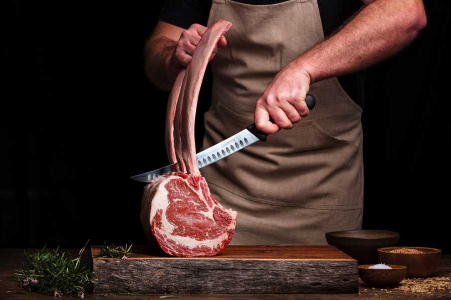 madie-hamilton-post-Copy-1 a man cutting a piece of raw beef steak - meat, a staple of the carnivore diet, is nutrient dense