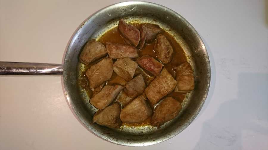 A frying pan full of large chunks of lean pork meat