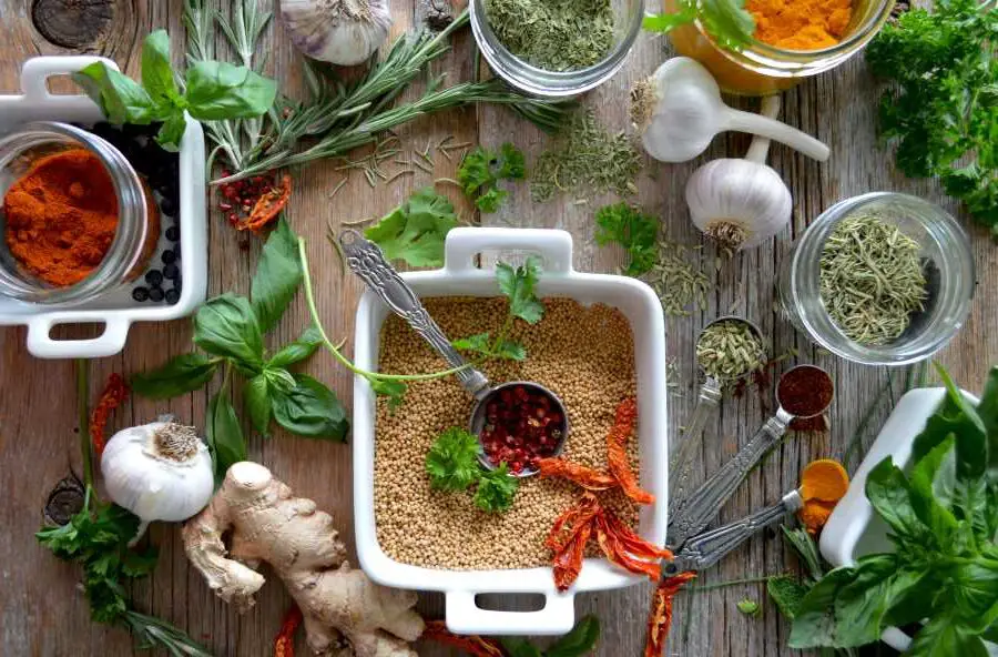 an image of various types of herbs and spices on a wooden table - herbs and spices are okay on the carnivore diet