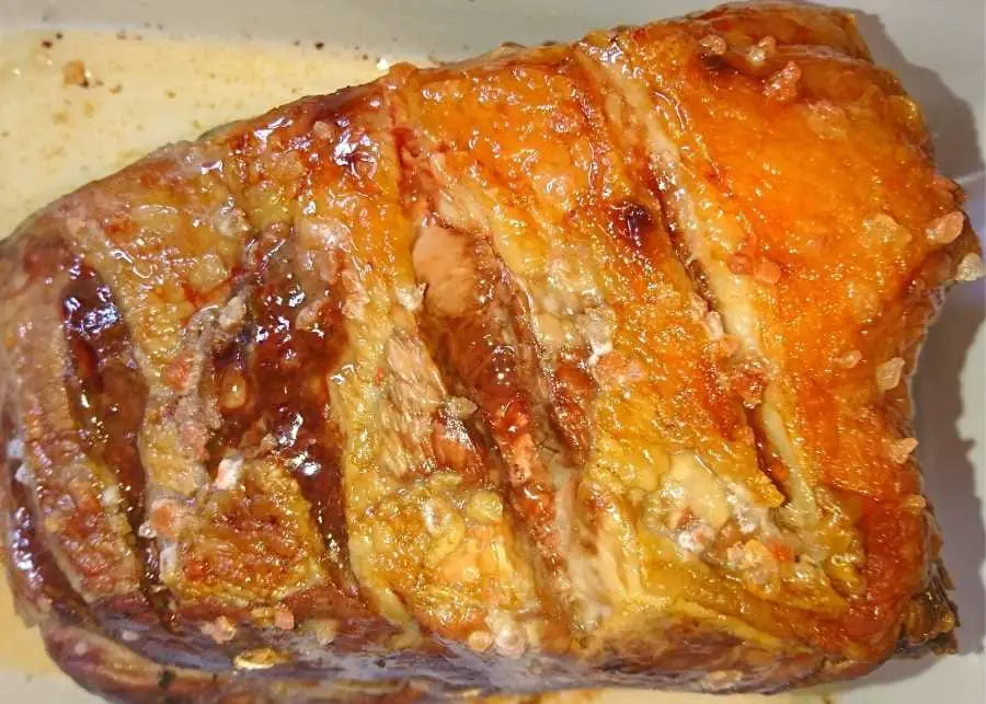 a roasted leg of lamb in a roasting dish
