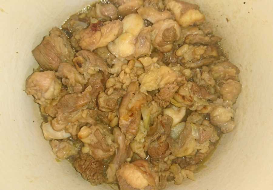 Browning beef tendons and onion in a pot