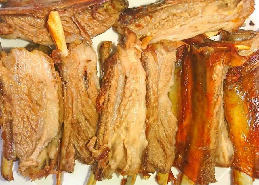 slices of roasted lamb ribs on a plate