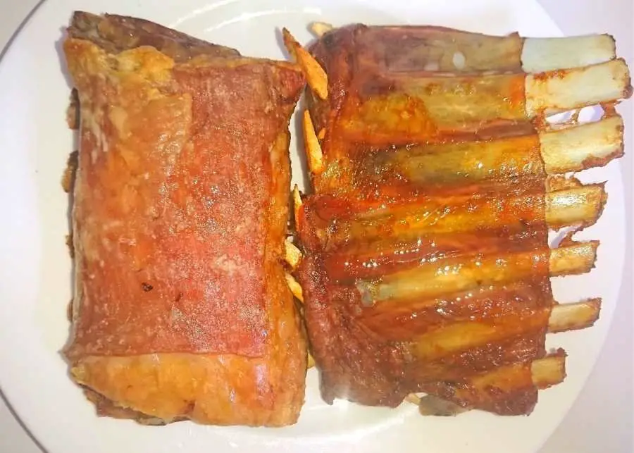 Two chunks of roasted lamb ribs on a plate