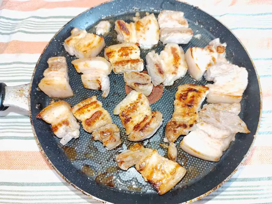 pork belly pieces being fried in a pan