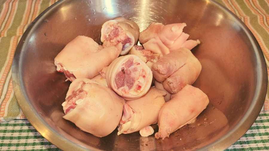 pig trotters being marinated in a bowl