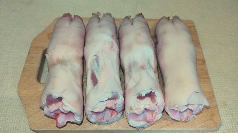uncooked pigs trotters on a chopping board