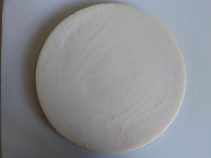chunk of beef tallow on a chopping board (after a double purifying process)