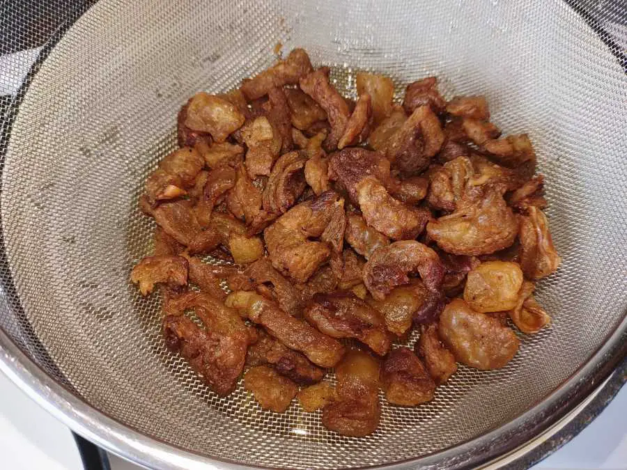 beef fat chips in a strainer