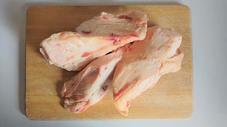 Three chunks of beef fat on a chopping board