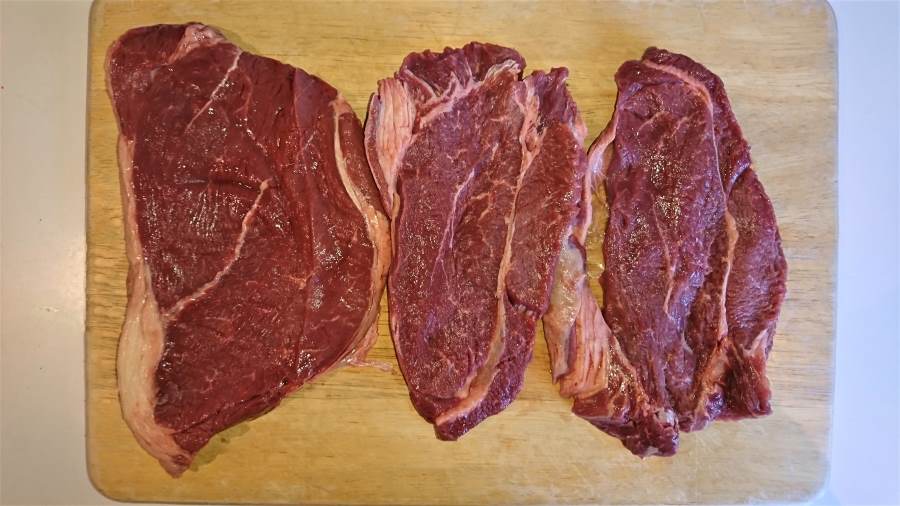 three blade steaks on a chopping board